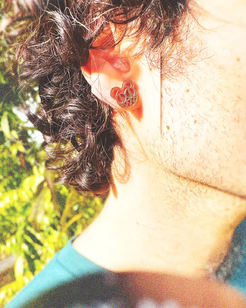 Photo of man with curly black hair wearing a stainless steel 0.5 inch radiohead earring.