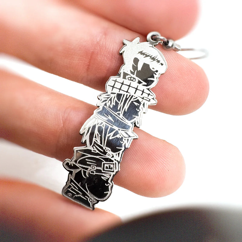 Hand holding hand-made stainless steel dangly earrings featuring the iconic Demon Days album design by Gorillaz.