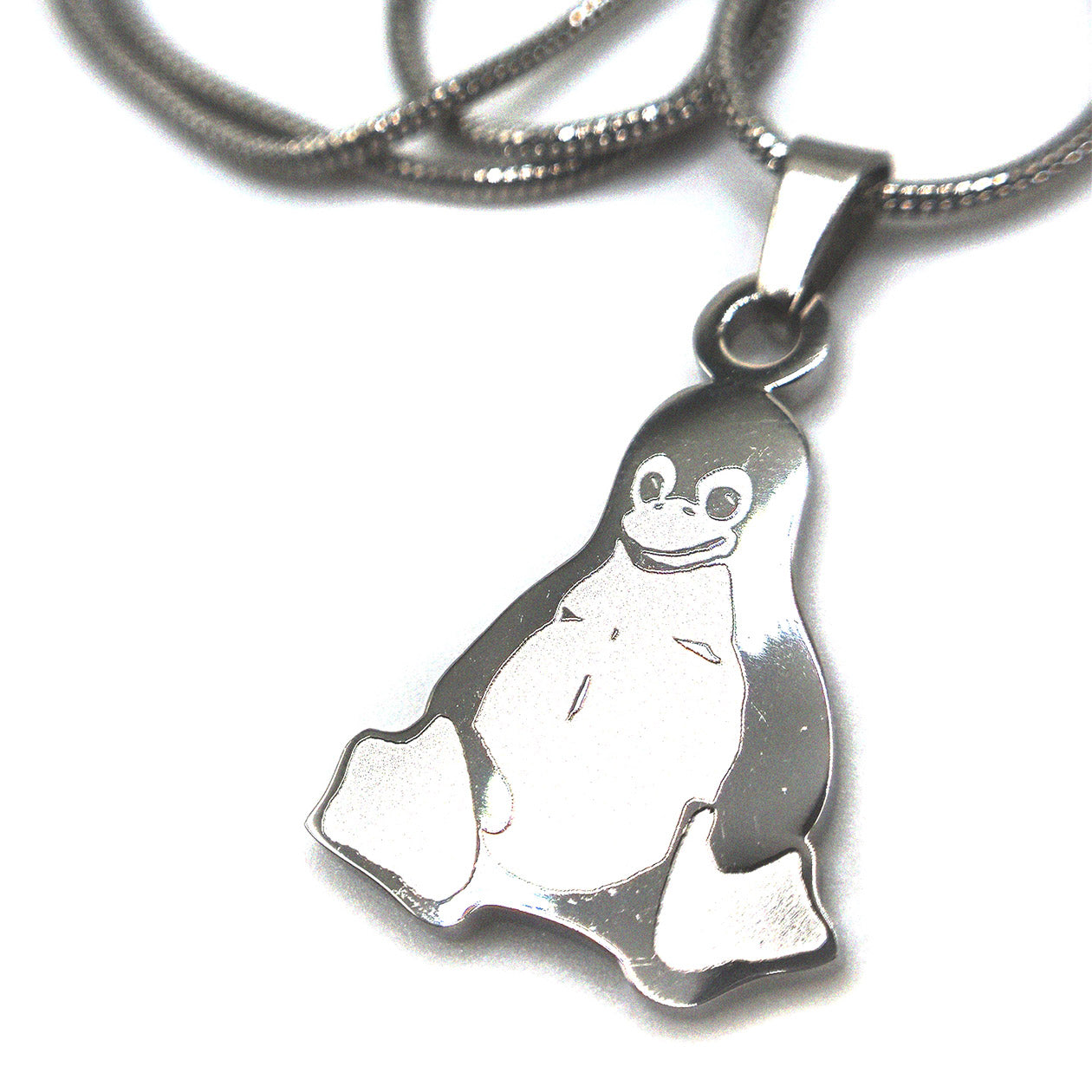 Detailed view of Linux Tux mascot pendant necklace in polished stainless steel