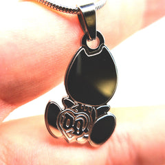 Drain Gang baby logo pendant necklace shown in hand for size reference, stainless steel