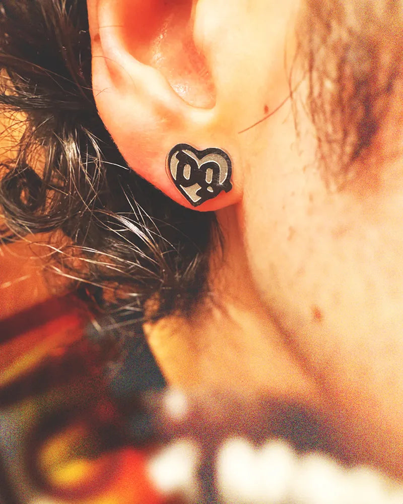 Close-up of a man wearing a 0.5-inch stainless steel stud earring inspired by Drain Gang