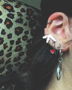 Girl wearing Aphex Twin logo small stud earrings – 0.5-inch stainless steel fan accessory