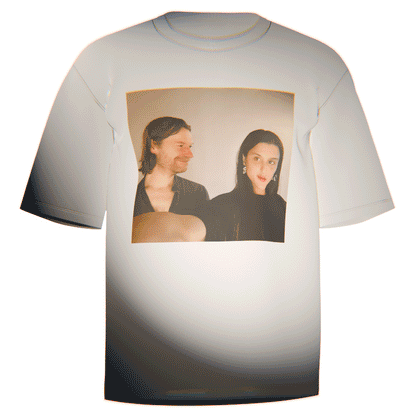 Flat-lay of a white Aphex Twin Arca T-Shirt featuring a vivid print of the iconic selfie of Arca and Richard D. James. Made in the USA from ultra-soft Comfort Colors 100% cotton. Perfect for showcasing your admiration for electronic music innovators.