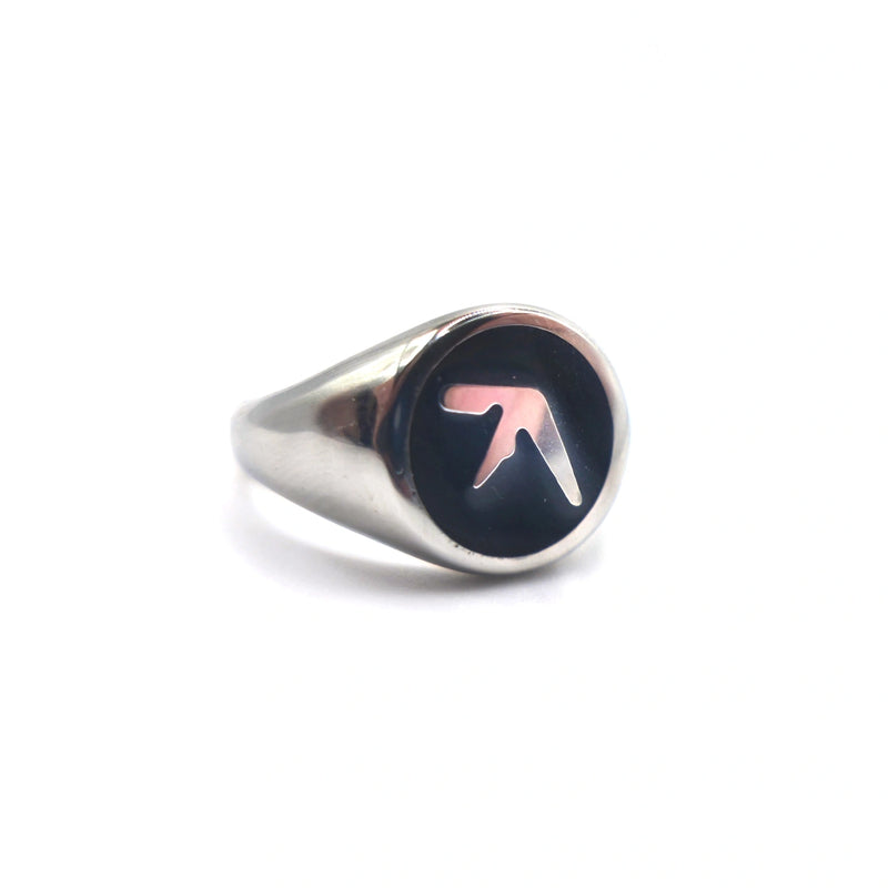 Stainless steel silver ring tilted to the side with an Aphex Logo on a black circular base