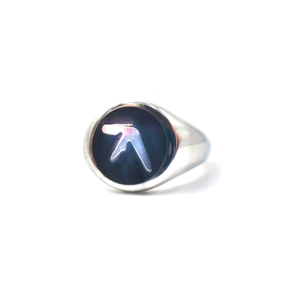 Stainless steel silver ring with an Aphex Logo on a black circular base