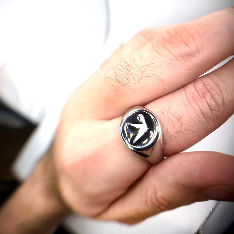 Photo of a hand wearing a stainless steel black enamel aphex twin ring on pointer finger white background
